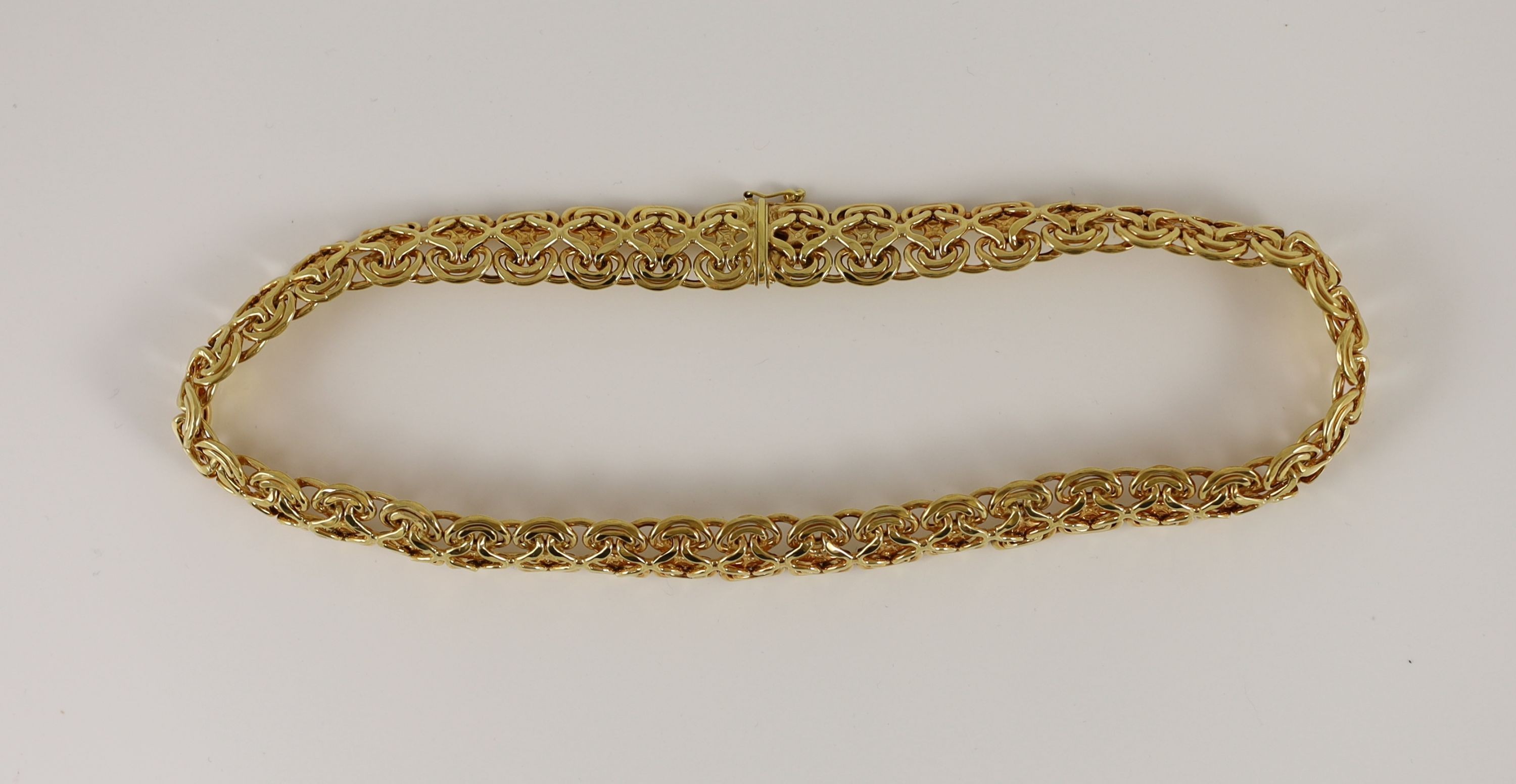 A modern 14k gold pierced scroll link necklace